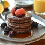Sourdough Pancake Recipe: Stack of fluffy sourdough pancakes topped with maple syrup and fresh berries.