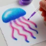 Child creating a colorful jellyfish salt painting using watercolor and glue on white cardstock