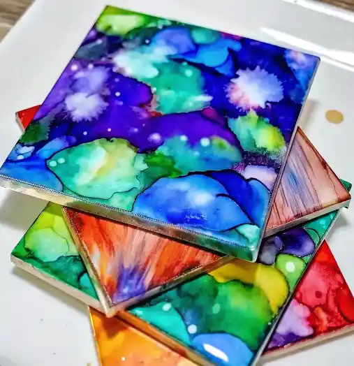 How to Paint With Sharpies and Alcohol: A Beautiful, Budget-Friendly DIY Anyone Can Do 3 Colorful ceramic tiles painted with Sharpies and alcohol ink in abstract watercolor patterns.
